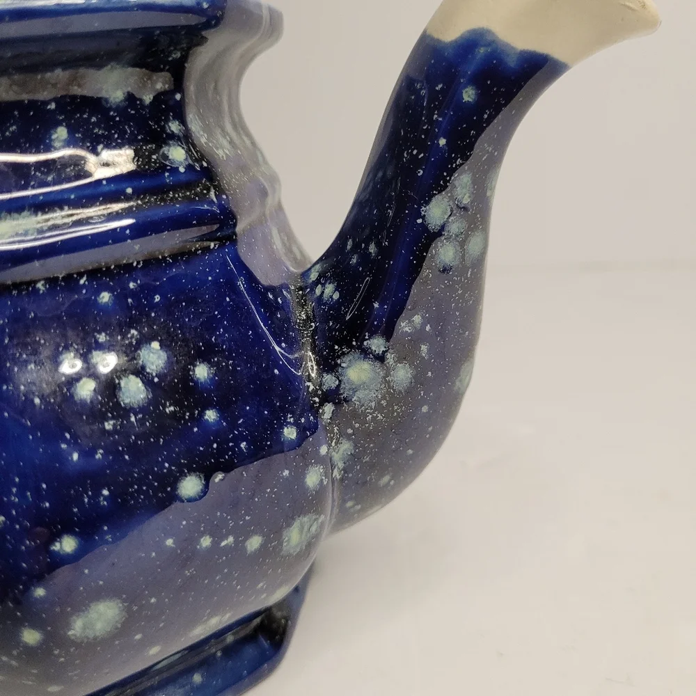 A blue and white speckled teapot. 271